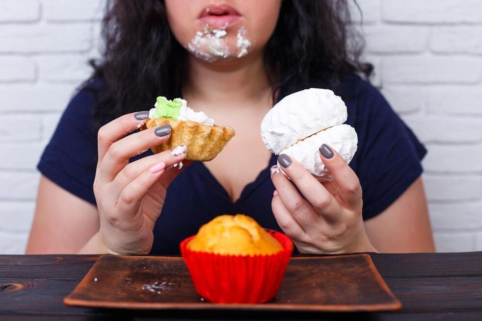 La donna sovrappeso mangia i dolci